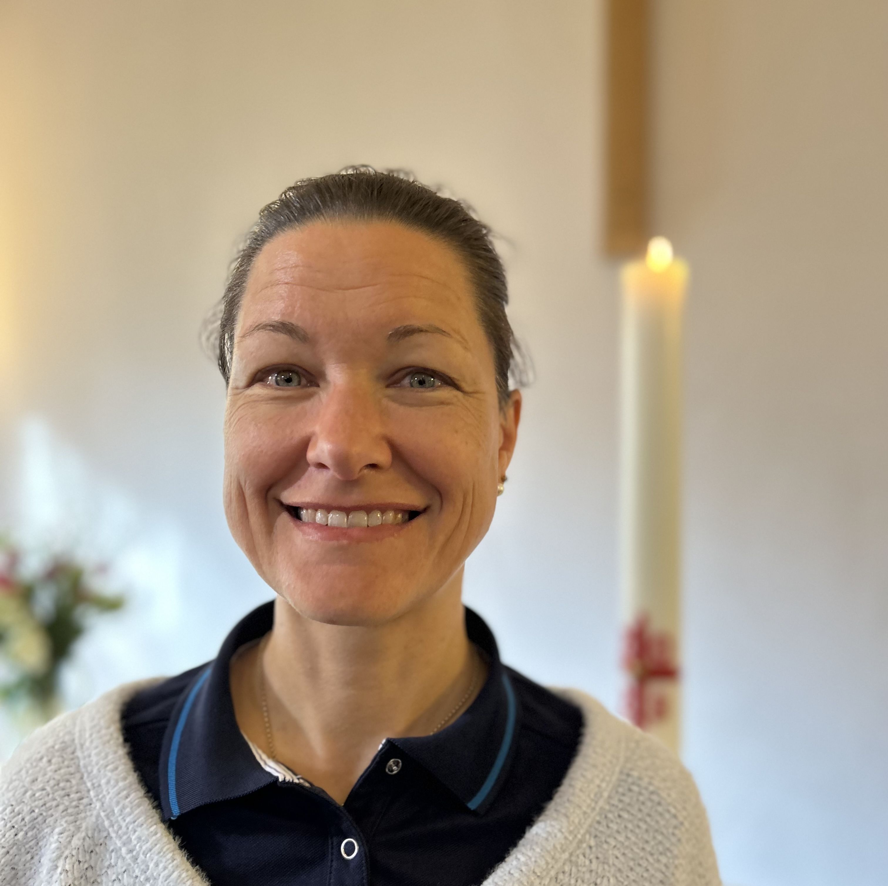 Portrait von Sonja Paas, im Hintergrund eine brennende Kerze und ein Kreuz an der Wand.