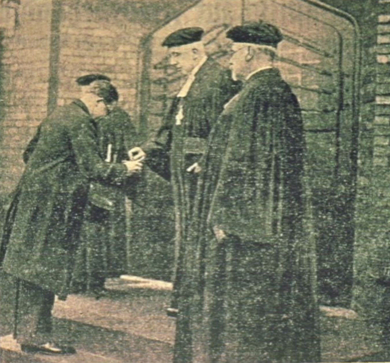 Drei Männer in Talar bzw. Frack bei der Kirchenweihe in Hösel. Der Architekt im Frack übergibt den Schlüssel zur Kirche an einen der Geistlichen (an den Generalsuperintendenten).