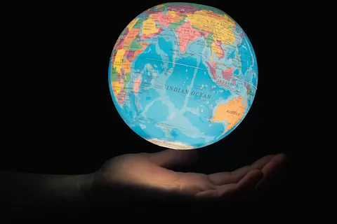Ein von innen beleuchteter Globus, schwebend über geöffneten Hand.