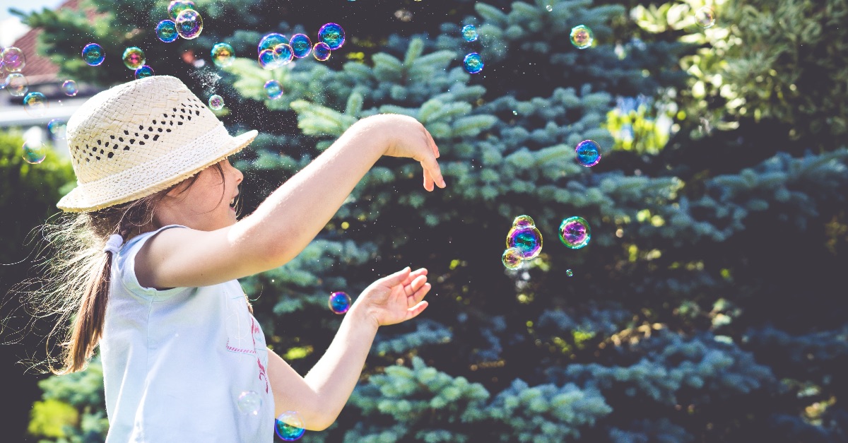 Kind spielt mit Seifenblasen